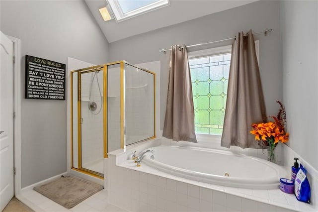 full bath with a skylight, a shower stall, a bath, and vaulted ceiling