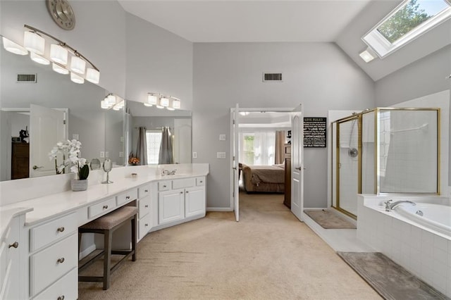 bathroom featuring high vaulted ceiling, a skylight, a stall shower, ensuite bath, and vanity