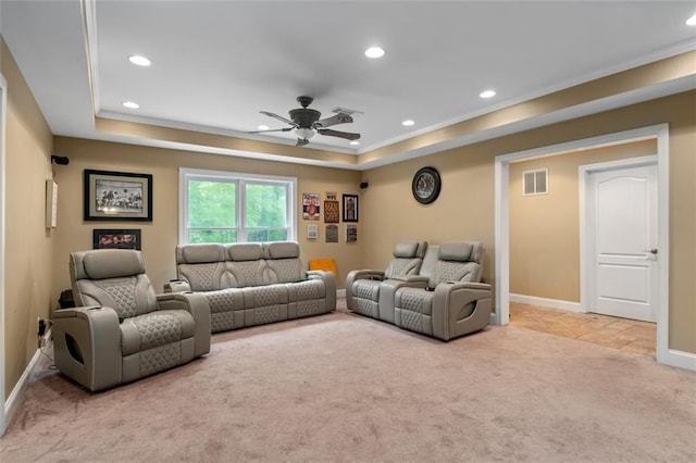 carpeted living room with a ceiling fan, a tray ceiling, recessed lighting, crown molding, and baseboards