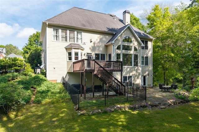 rear view of property featuring stairway, a deck, a patio area, and a chimney