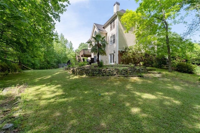 view of green lawn with a deck
