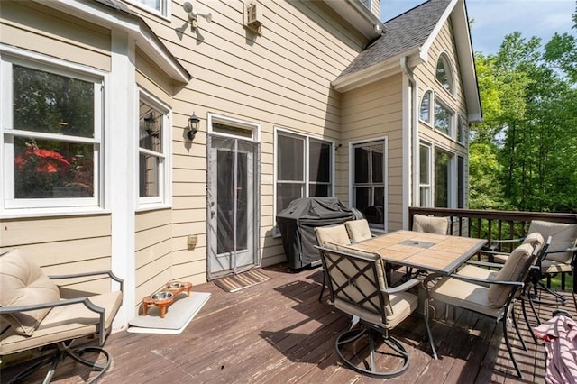 wooden terrace with grilling area and outdoor dining space