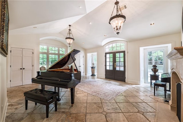 foyer with french doors, vaulted ceiling, stone tile flooring, a chandelier, and recessed lighting