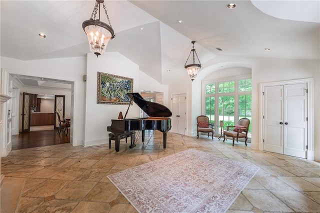 living area with stone tile floors, a chandelier, vaulted ceiling, and recessed lighting
