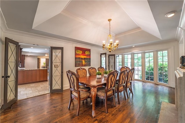 dining space with an inviting chandelier, ornamental molding, baseboards, a tray ceiling, and dark wood-style floors