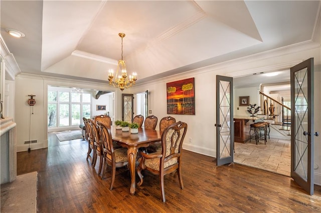 dining space with crown molding, an inviting chandelier, a raised ceiling, baseboards, and dark wood-style floors