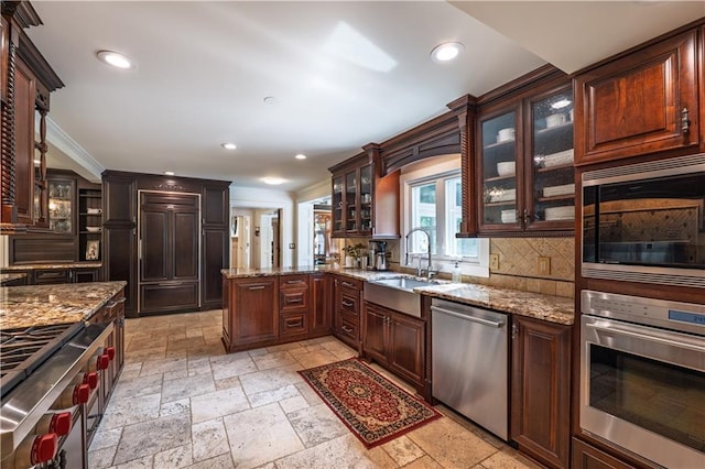 kitchen with stone tile flooring, light stone countertops, recessed lighting, a sink, and stainless steel appliances
