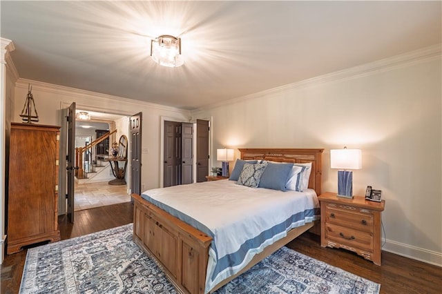 bedroom featuring dark wood-type flooring, ornamental molding, and baseboards
