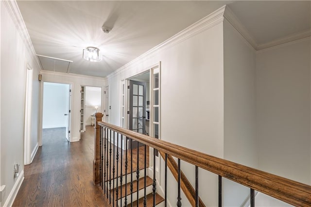 hall featuring dark wood-type flooring, attic access, an upstairs landing, and ornamental molding