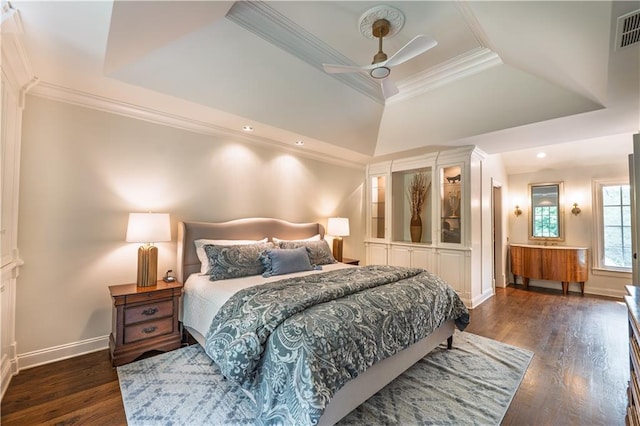 bedroom with visible vents, ornamental molding, baseboards, dark wood-type flooring, and a tray ceiling
