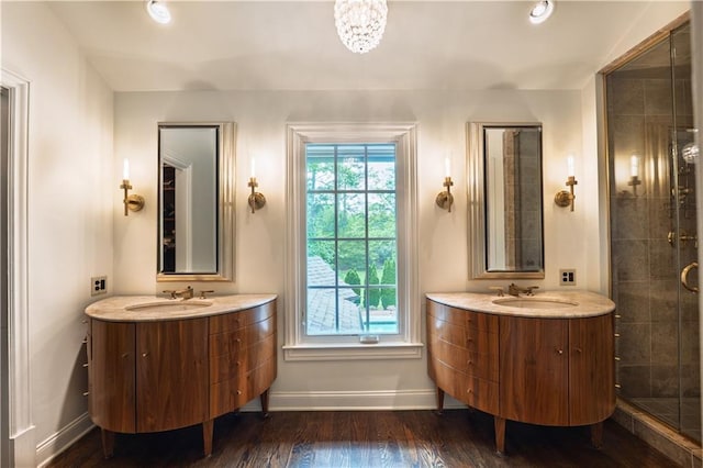 full bath with baseboards, vanity, a stall shower, and wood finished floors