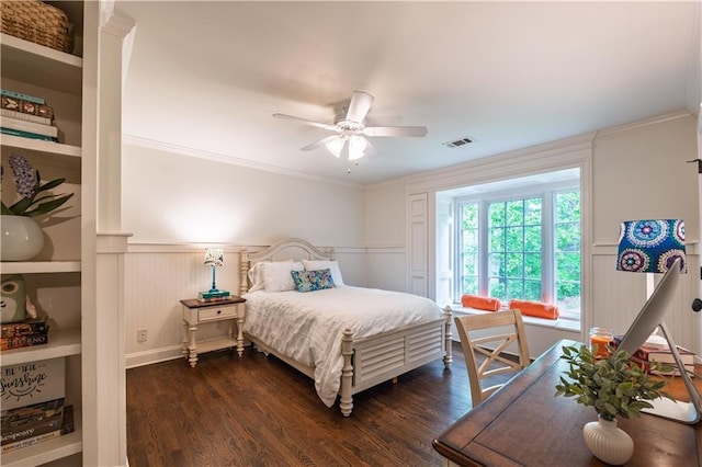 bedroom featuring a decorative wall, visible vents, and dark wood-style floors