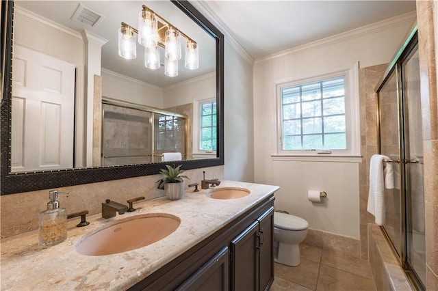 bathroom featuring a tile shower, toilet, visible vents, and a sink