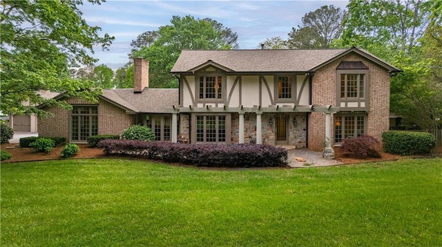 view of front of property with a chimney, stone siding, stucco siding, and a front lawn