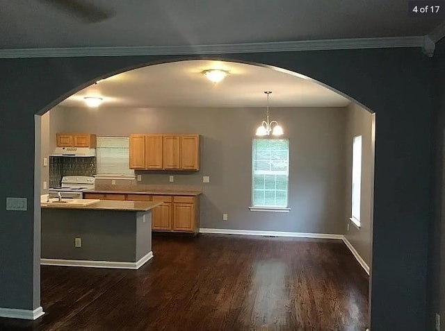 kitchen featuring light brown cabinets, white electric stove, light countertops, and arched walkways