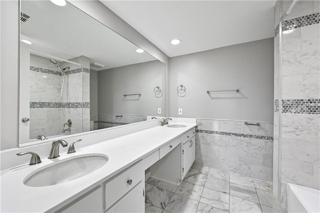 full bathroom with recessed lighting, tiled shower, a sink, and marble finish floor