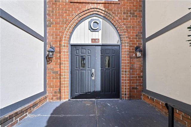 entrance to property featuring brick siding