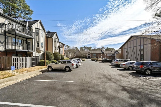 uncovered parking lot with fence and a residential view