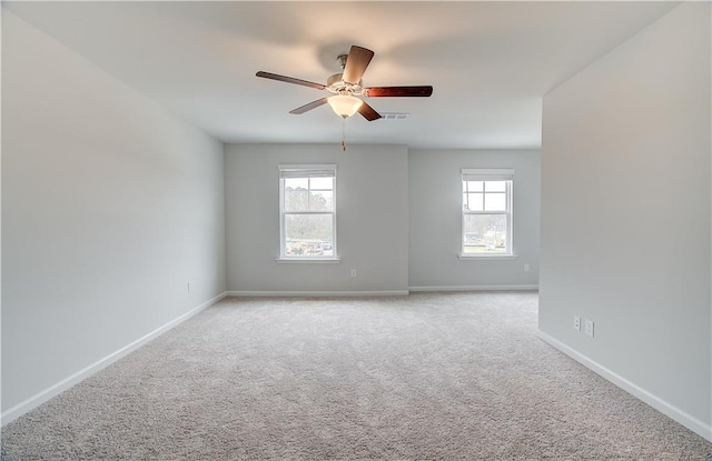 carpeted spare room featuring ceiling fan