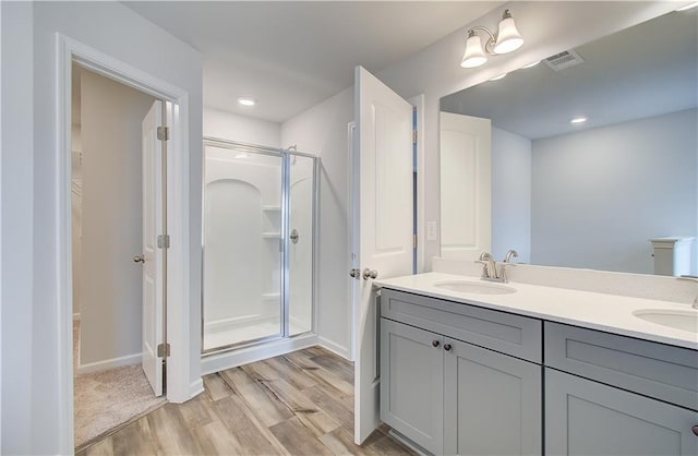 bathroom featuring wood-type flooring, vanity, and walk in shower