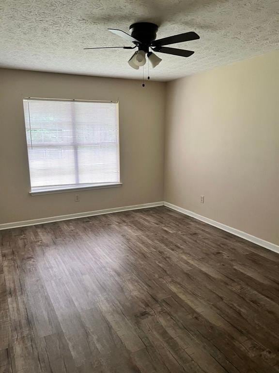 432 Manor Estates Dr, Stockbridge, GA 30281 - spare room featuring dark wood-style flooring, plenty of natural light, a ceiling fan, baseboards, and a textured ceiling