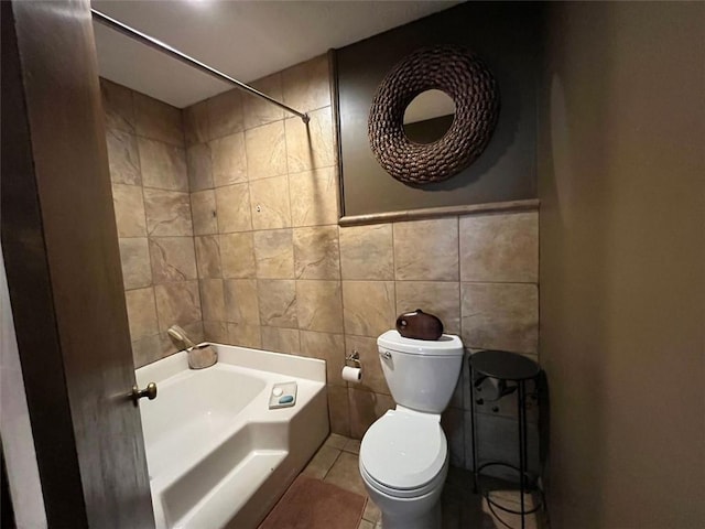 bathroom featuring tile walls, tile patterned floors, toilet, and bathtub / shower combination