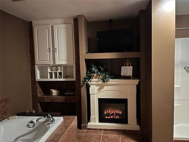 bathroom with tile patterned flooring, tiled bath, and built in features