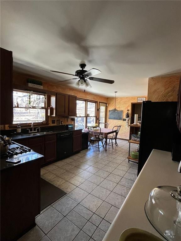 kitchen featuring light tile patterned flooring, pendant lighting, sink, and black appliances