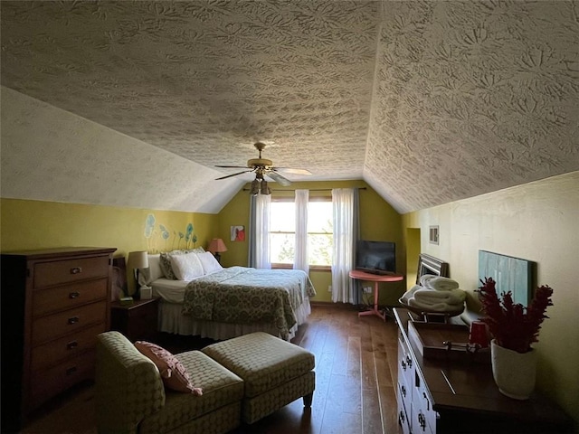 bedroom featuring dark hardwood / wood-style flooring, a textured ceiling, vaulted ceiling, and ceiling fan