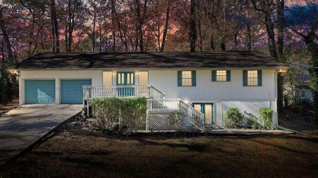 view of front facade featuring an attached garage, concrete driveway, and stairs