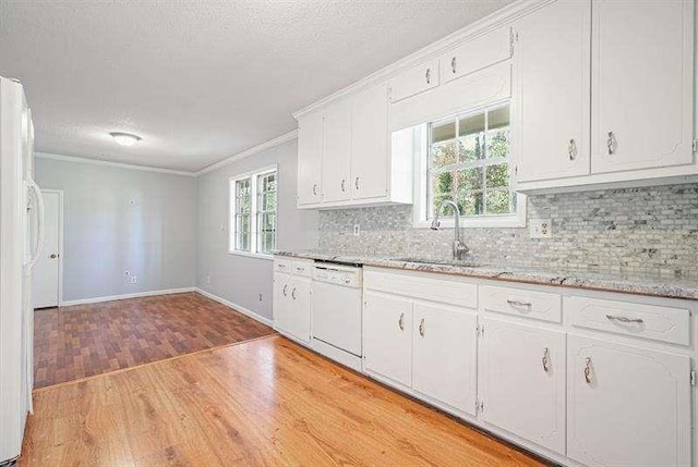 kitchen with a sink, white appliances, crown molding, and light wood finished floors