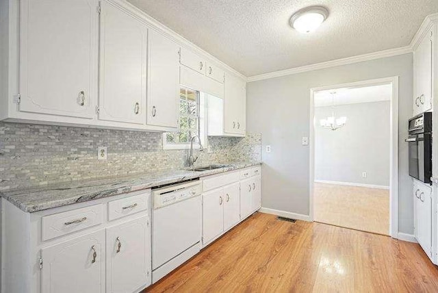 kitchen with light wood finished floors, black oven, white dishwasher, white cabinetry, and a sink