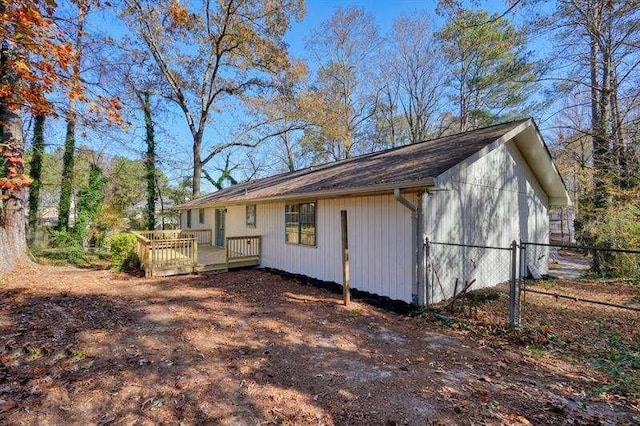 back of house featuring a deck and fence