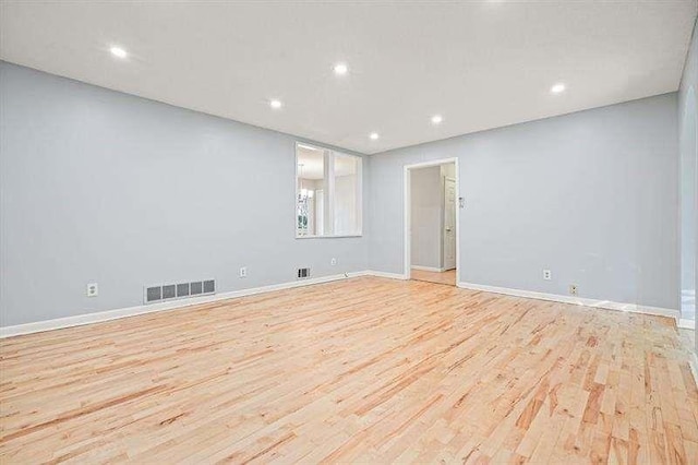 unfurnished room featuring visible vents, recessed lighting, light wood-type flooring, and baseboards