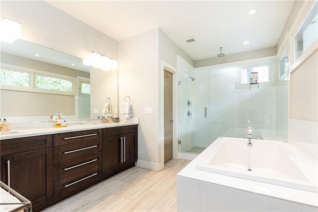 bathroom featuring independent shower and bath and vanity