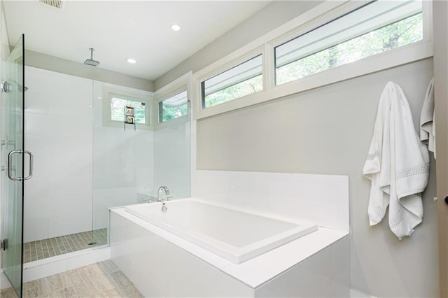 bathroom featuring independent shower and bath and a healthy amount of sunlight