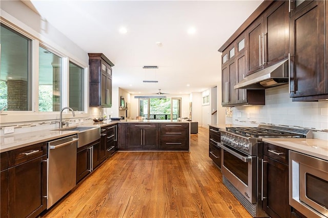 kitchen featuring light hardwood / wood-style flooring, ceiling fan, sink, decorative backsplash, and stainless steel appliances