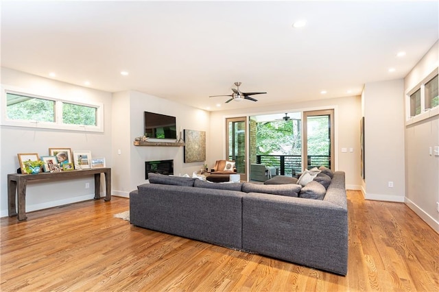 living room featuring light wood-type flooring and ceiling fan