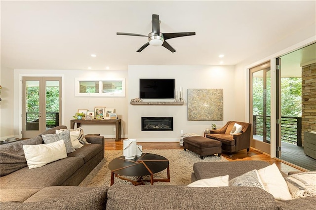 living room featuring ceiling fan and light hardwood / wood-style flooring