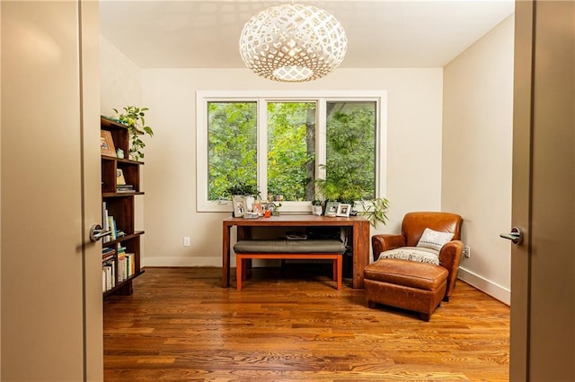 sitting room featuring a notable chandelier and hardwood / wood-style flooring