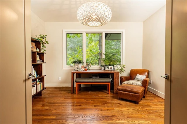 living area featuring hardwood / wood-style floors and a notable chandelier