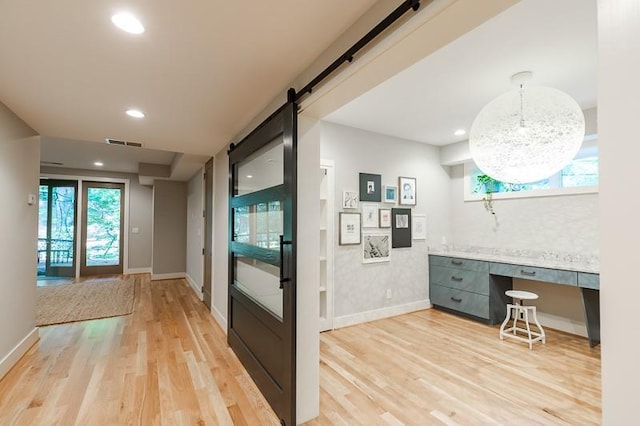 hall featuring a barn door and wood-type flooring