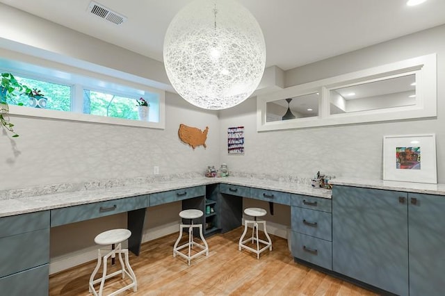 home office featuring built in desk and light hardwood / wood-style flooring