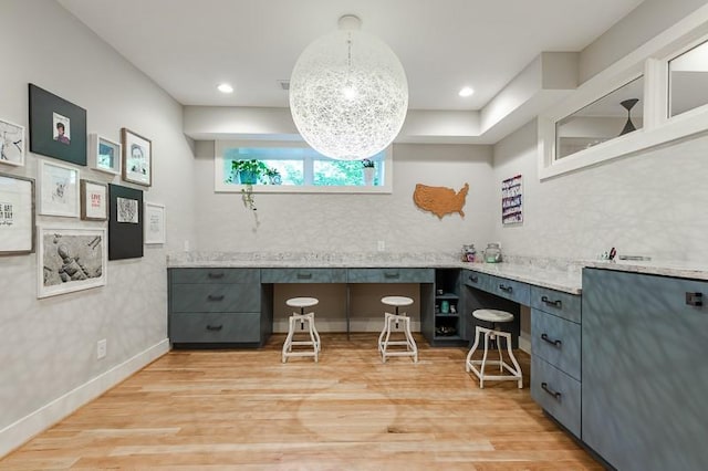 office with built in desk and light hardwood / wood-style flooring