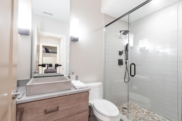 bathroom featuring vanity, toilet, and an enclosed shower