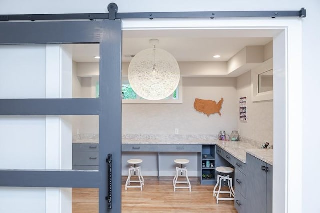 interior space featuring light stone counters, light hardwood / wood-style flooring, and gray cabinets