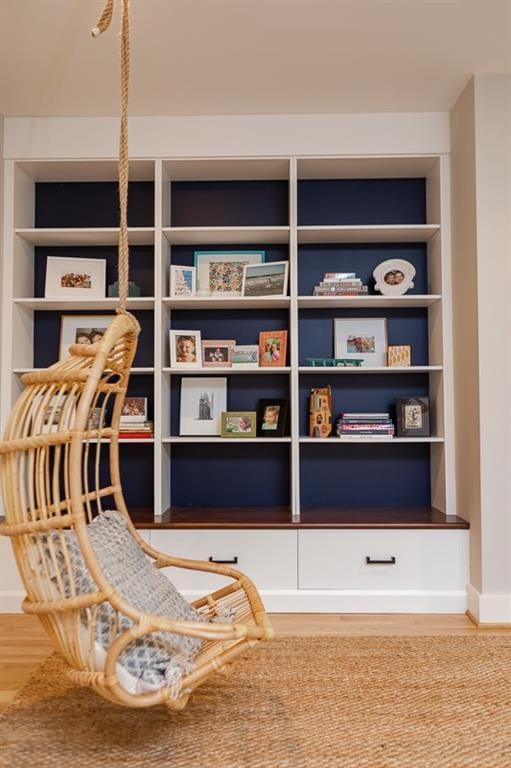 living area with built in features and hardwood / wood-style flooring