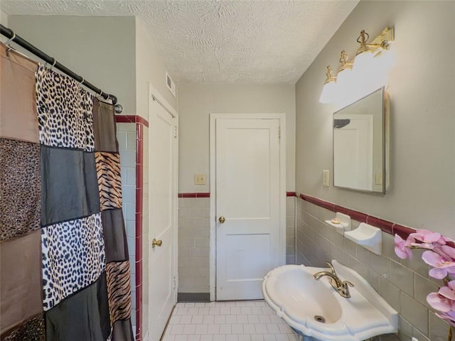 646 Quillian Ave, Decatur, GA 30032 - full bathroom with a sink, a textured ceiling, tile walls, and a shower with shower curtain