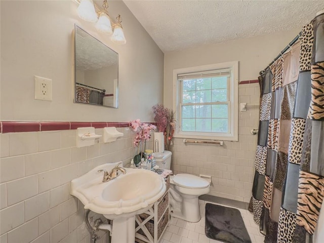 646 Quillian Ave, Decatur, GA 30032 - full bath with a textured ceiling, tile walls, tile patterned flooring, a wainscoted wall, and toilet