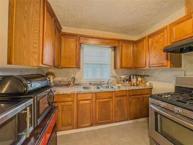 646 Quillian Ave, Decatur, GA 30032 - kitchen with under cabinet range hood, a sink, brown cabinetry, and gas stove